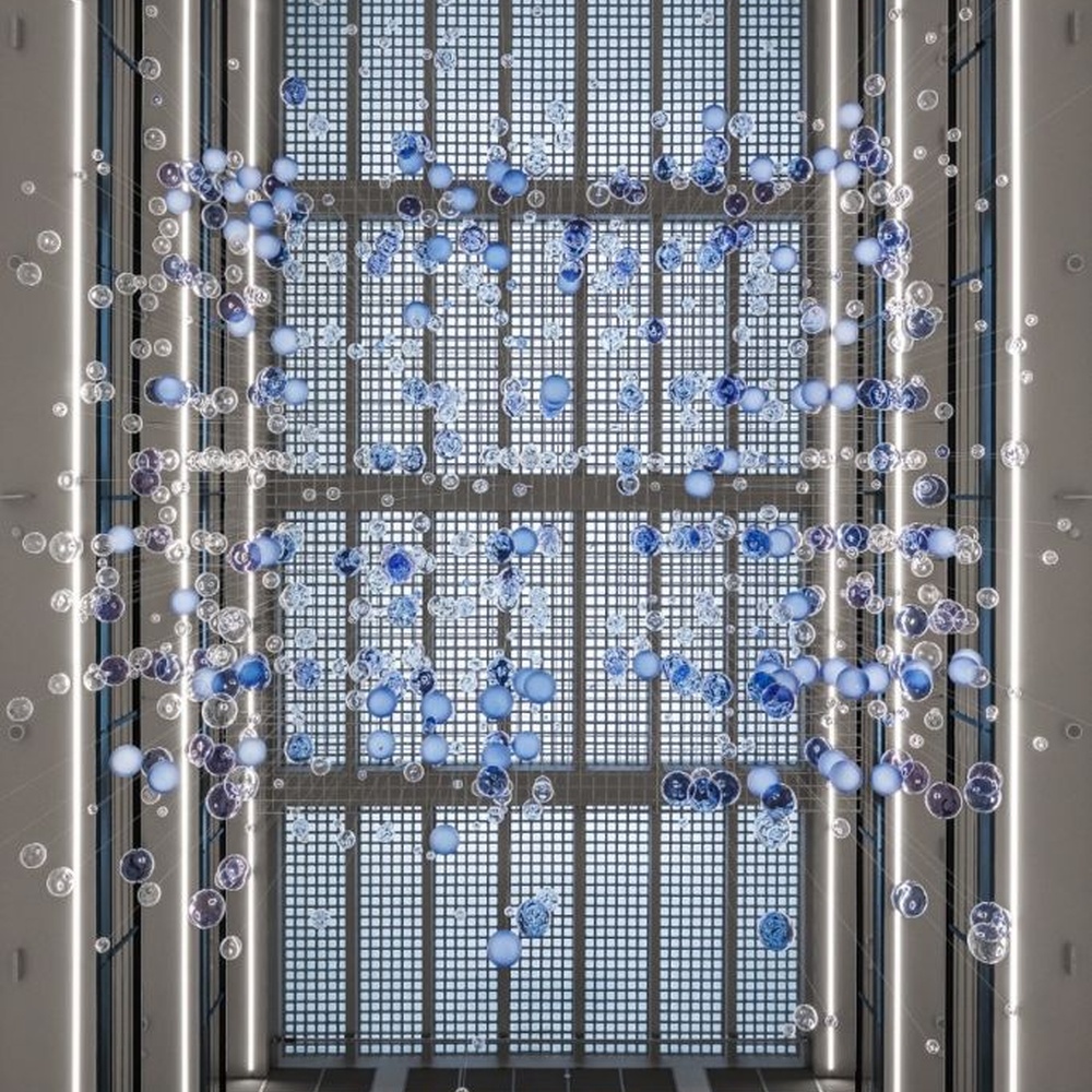 This is a modern art-style suspended bubble installation lamp, composed of transparent and blue-purple gradient spherical elements hung in a staggered manner, with both decorative and lighting functions, ideal for multi-story high-ceiling public spaces such as shopping mall atriums and office building lobbies.