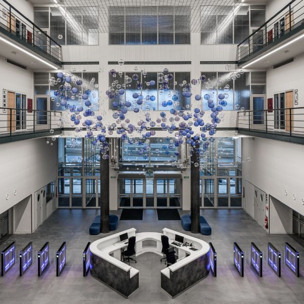 This is a modern art-style suspended bubble installation lamp, composed of transparent and blue-purple gradient spherical elements hung in a staggered manner, with both decorative and lighting functions, ideal for multi-story high-ceiling public spaces such as shopping mall atriums and office building lobbies.
