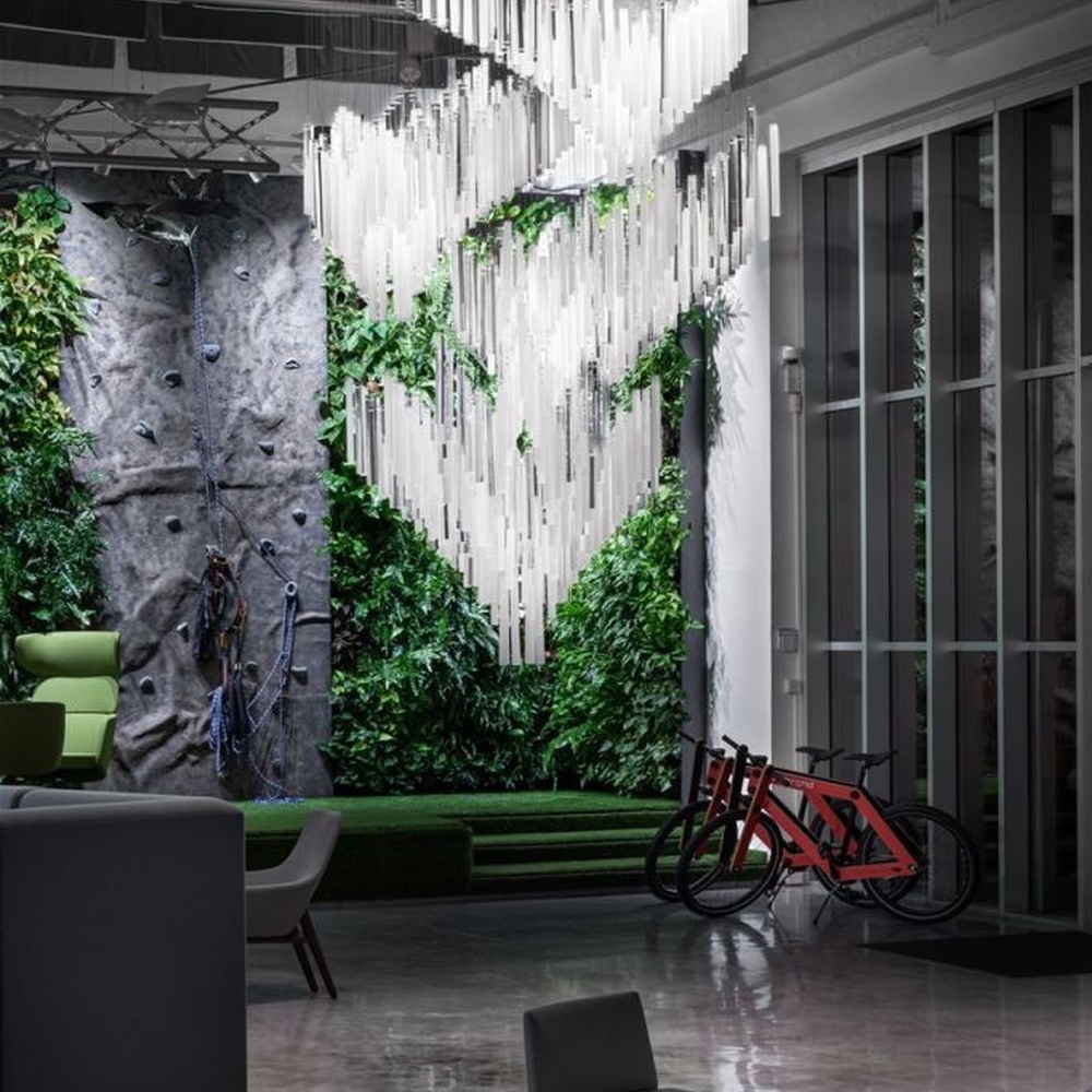 This modern industrial-style art chandelier consists of a large number of white acrylic strips hung staggered by metal wires, extending downward in a waterfall shape from a circular ceiling plate. Light passes through the strips to emit a transparent and soft halo, serving both lighting and decorative purposes, suitable for high-ceiling commercial spaces such as cultural and creative parks and art exhibition halls.