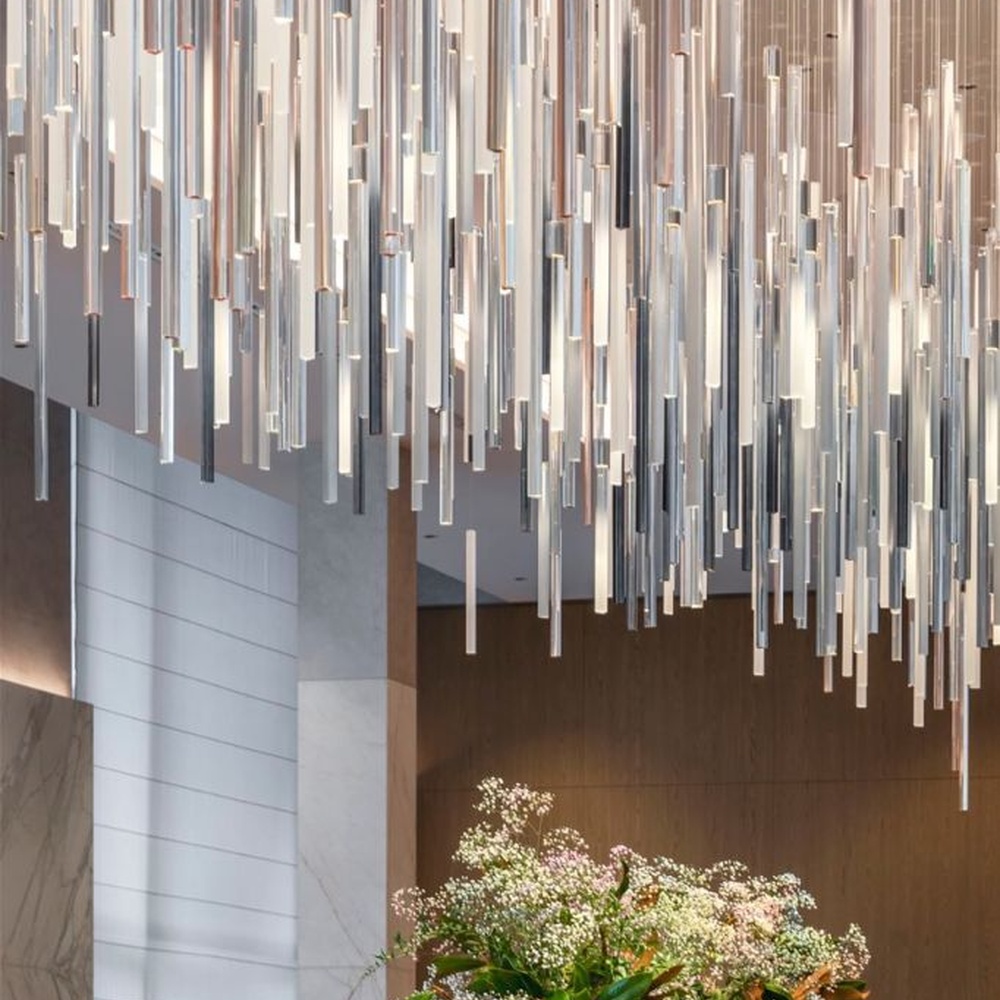 This is a modern minimalist large pendant crystal chandelier, composed of densely hung transparent and translucent crystal tubes, creating a dynamic light waterfall effect, with both decorative and lighting functions, ideal for high-ceiling commercial spaces such as high-end restaurants and hotel lobbies.