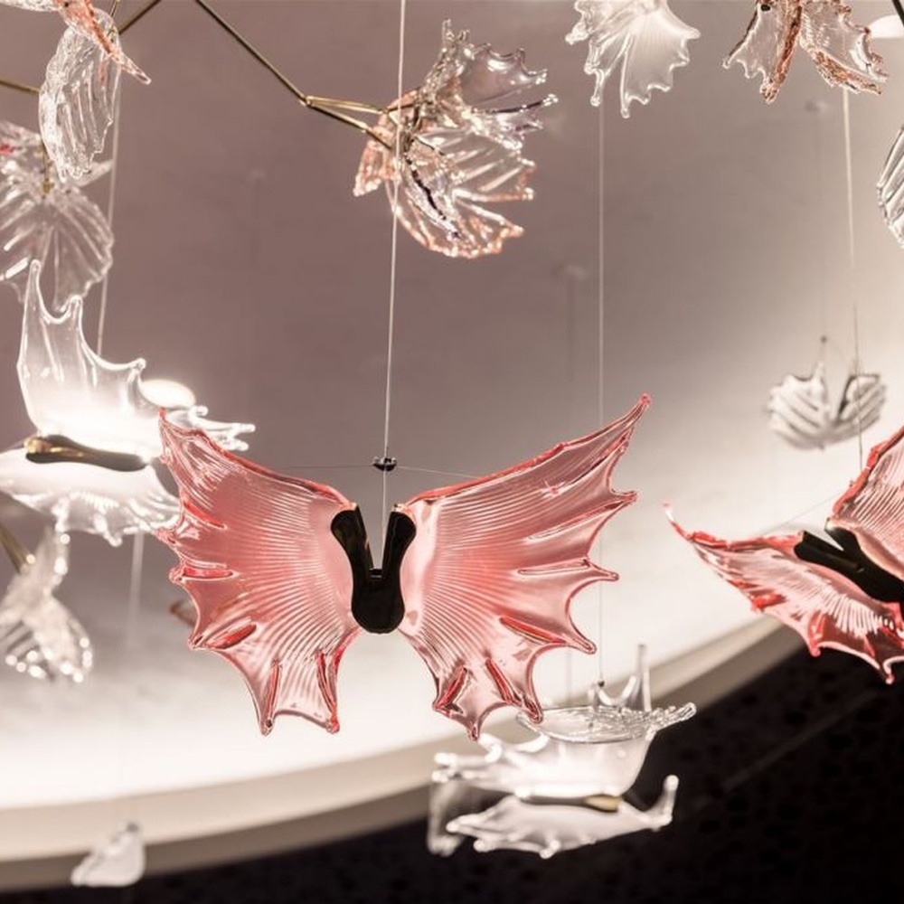 This is a customized artistic flower ceiling chandelier, composed of flower and branch-shaped components made of transparent and red-pink glass/acrylic material, paired with a circular luminous ceiling plate, which has both lighting and artistic decoration functions, suitable for large commercial spaces such as hotel lobbies, banquet halls, and high-end clubs.