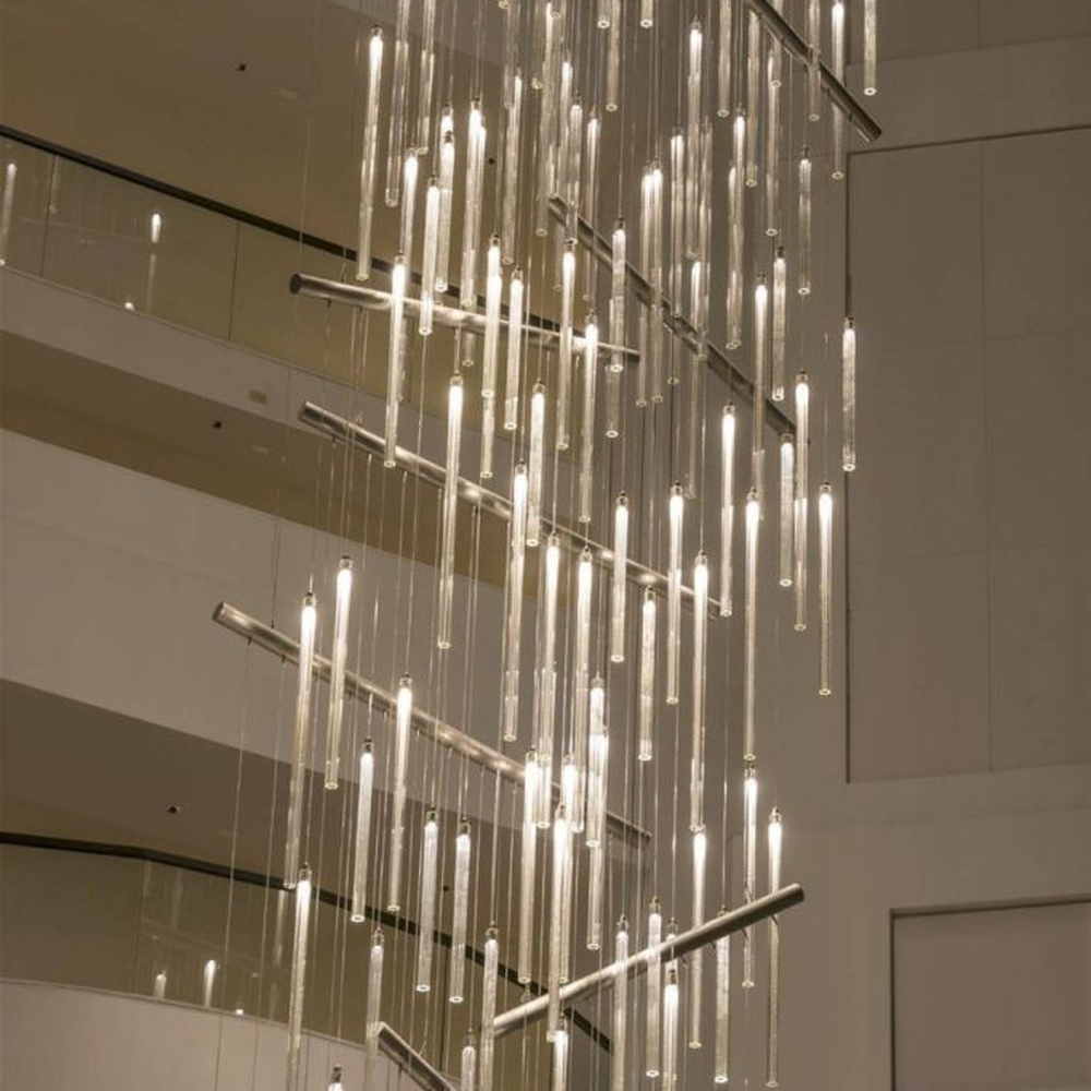 This modern light rain art lighting group consists of a large number of slender linear light strips hanging vertically, creating a "pouring light rain" visual effect with a wooden background wall, serving both lighting and installation art purposes, suitable for high-ceiling commercial spaces such as hotel lobbies and convention centers.