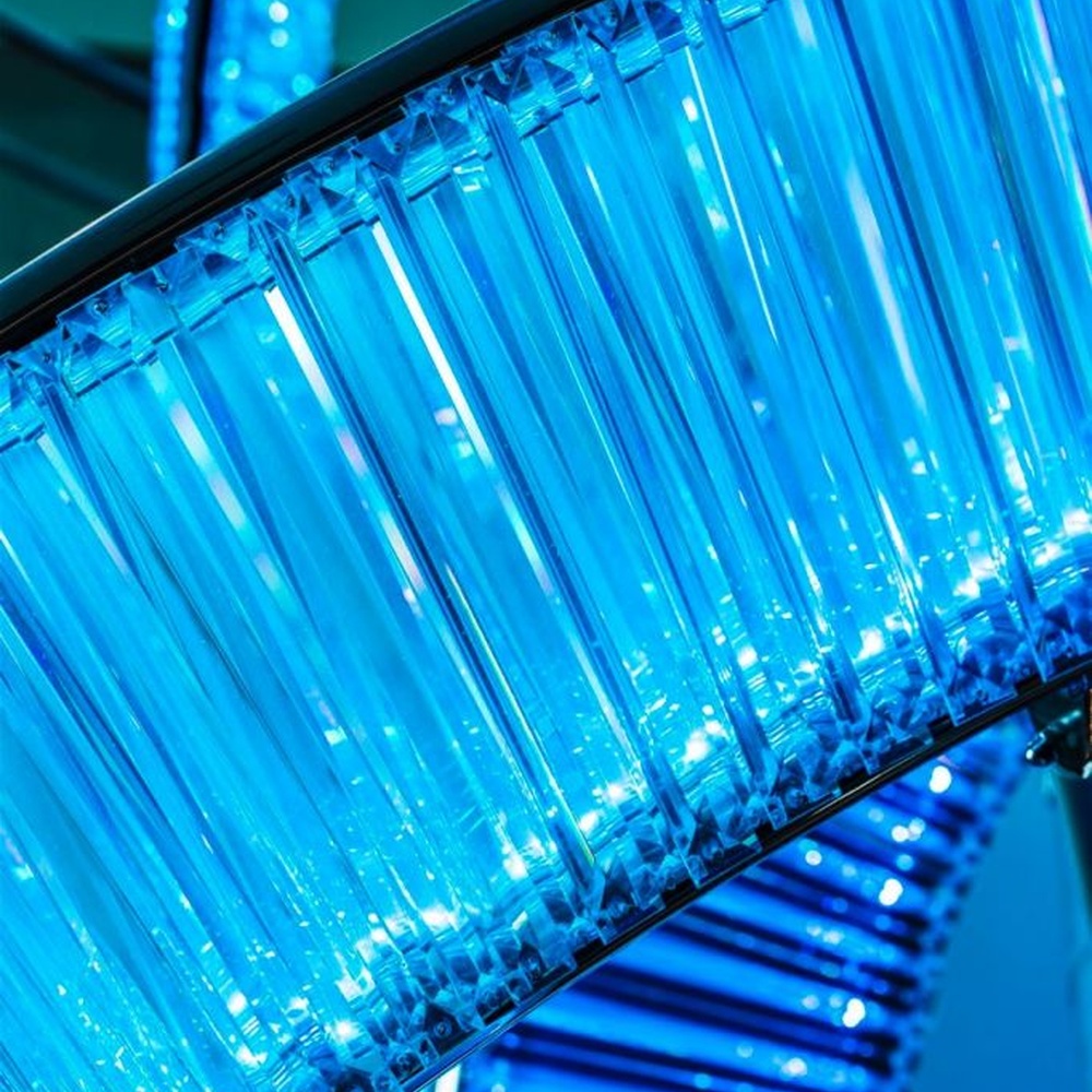 This is a large suspended art installation lamp, supported by a metal frame with blue-purple-cyan gradient LED light strips, featuring an abstract spiral and crescent shape, with both decorative and lighting functions, ideal as artistic decorative lighting for public spaces.