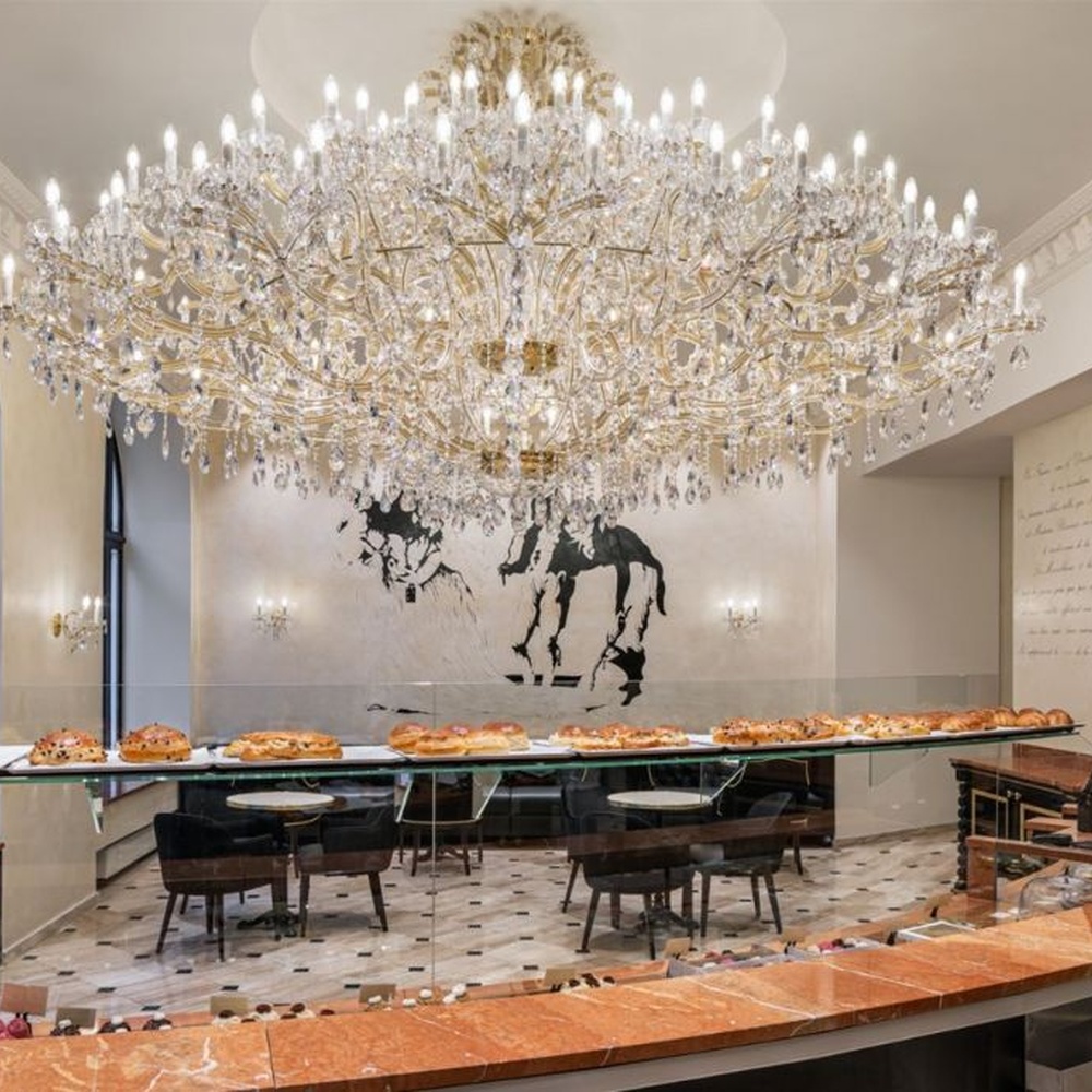 This is a luxurious large chandelier, supported by a gold metal frame with multi-layer crystal pendants, featuring a blooming and gorgeous shape, with brilliant and dazzling light, both decorative and lighting functions, ideal for large commercial spaces such as high-end restaurants and hotel lobbies.
