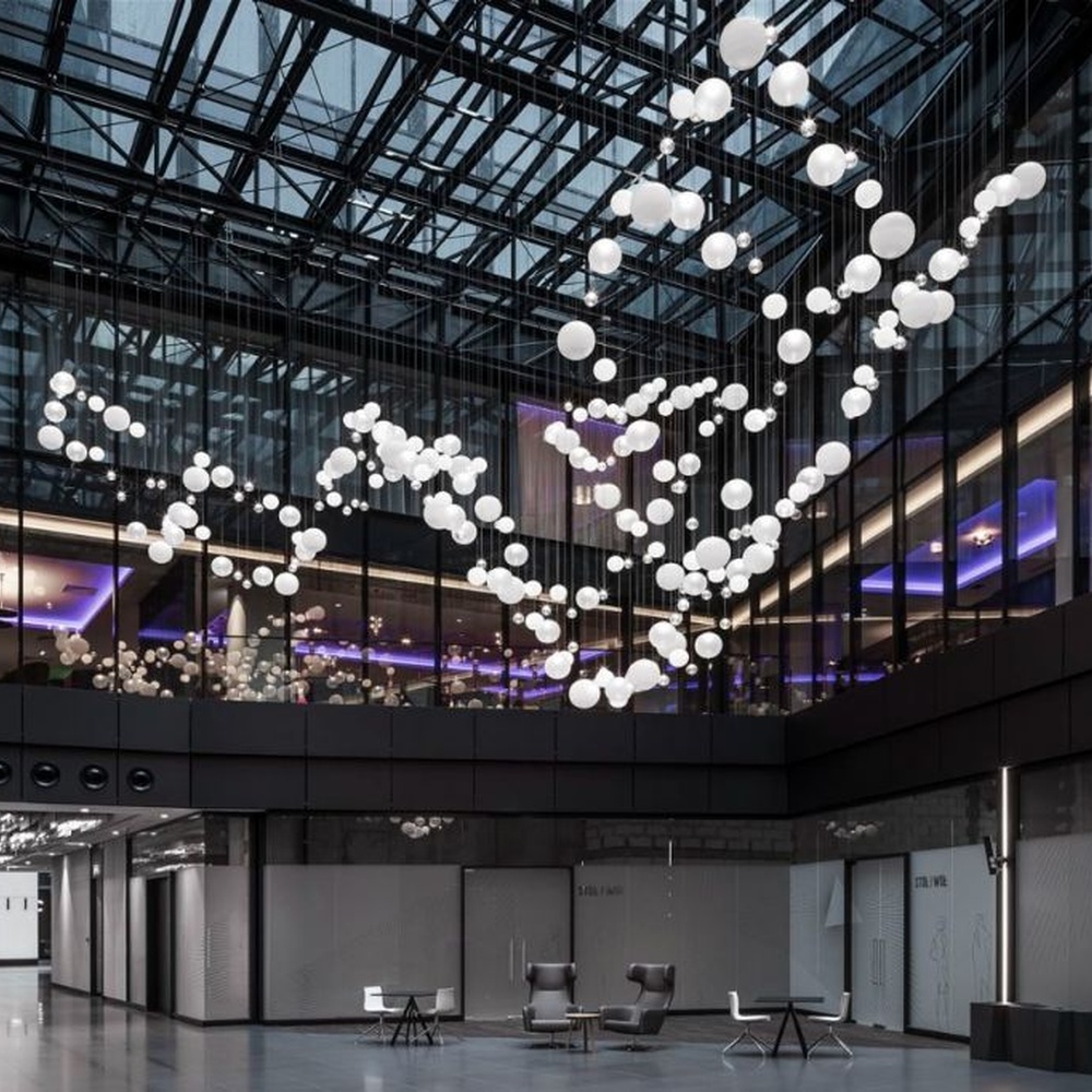 This is a modern art-style suspended spherical light array, composed of densely hung white spherical LED lights of varying sizes, presenting a flowing cloud cluster effect, with both decorative and lighting functions, ideal for public commercial spaces such as shopping mall atriums and high-ceiling office buildings.