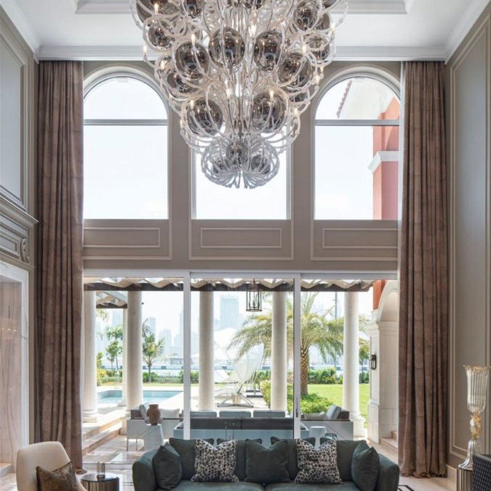 This European luxury art crystal chandelier is made of hand-blown transparent glass/crystal, with an irregular curled and twisted shape that presents a visual effect like a blooming firework. The light refracts through the crystal to emit a brilliant glow, serving both lighting and decorative purposes, suitable for luxury spaces such as high-ceiling villa living rooms and high-end clubs.