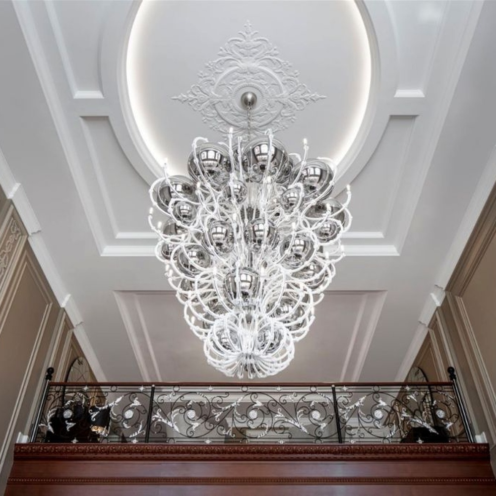 This European luxury art crystal chandelier is made of hand-blown transparent glass/crystal, with an irregular curled and twisted shape that presents a visual effect like a blooming firework. The light refracts through the crystal to emit a brilliant glow, serving both lighting and decorative purposes, suitable for luxury spaces such as high-ceiling villa living rooms and high-end clubs.