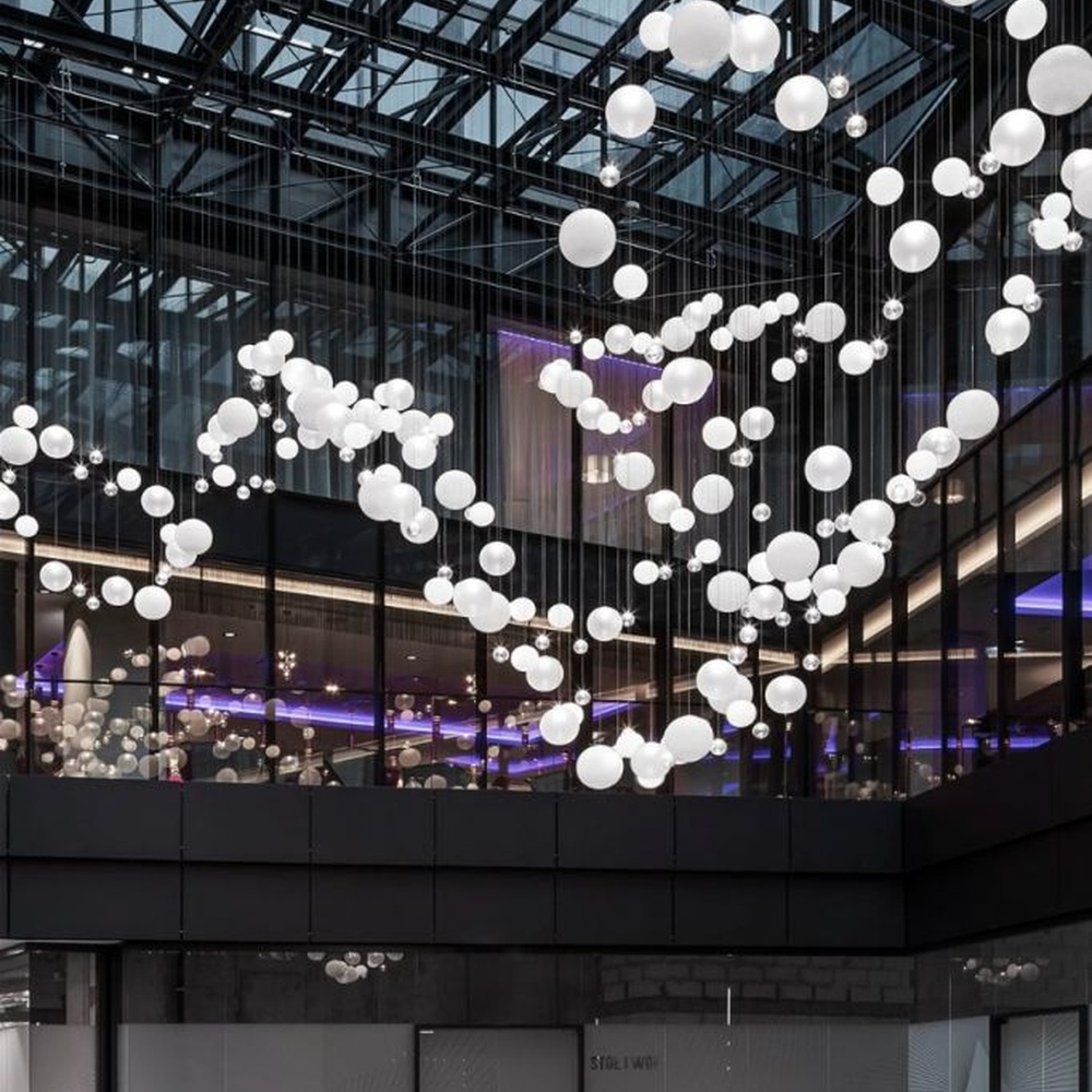 This is a modern art-style suspended spherical light array, composed of densely hung white spherical LED lights of varying sizes, presenting a flowing cloud cluster effect, with both decorative and lighting functions, ideal for public commercial spaces such as shopping mall atriums and high-ceiling office buildings.