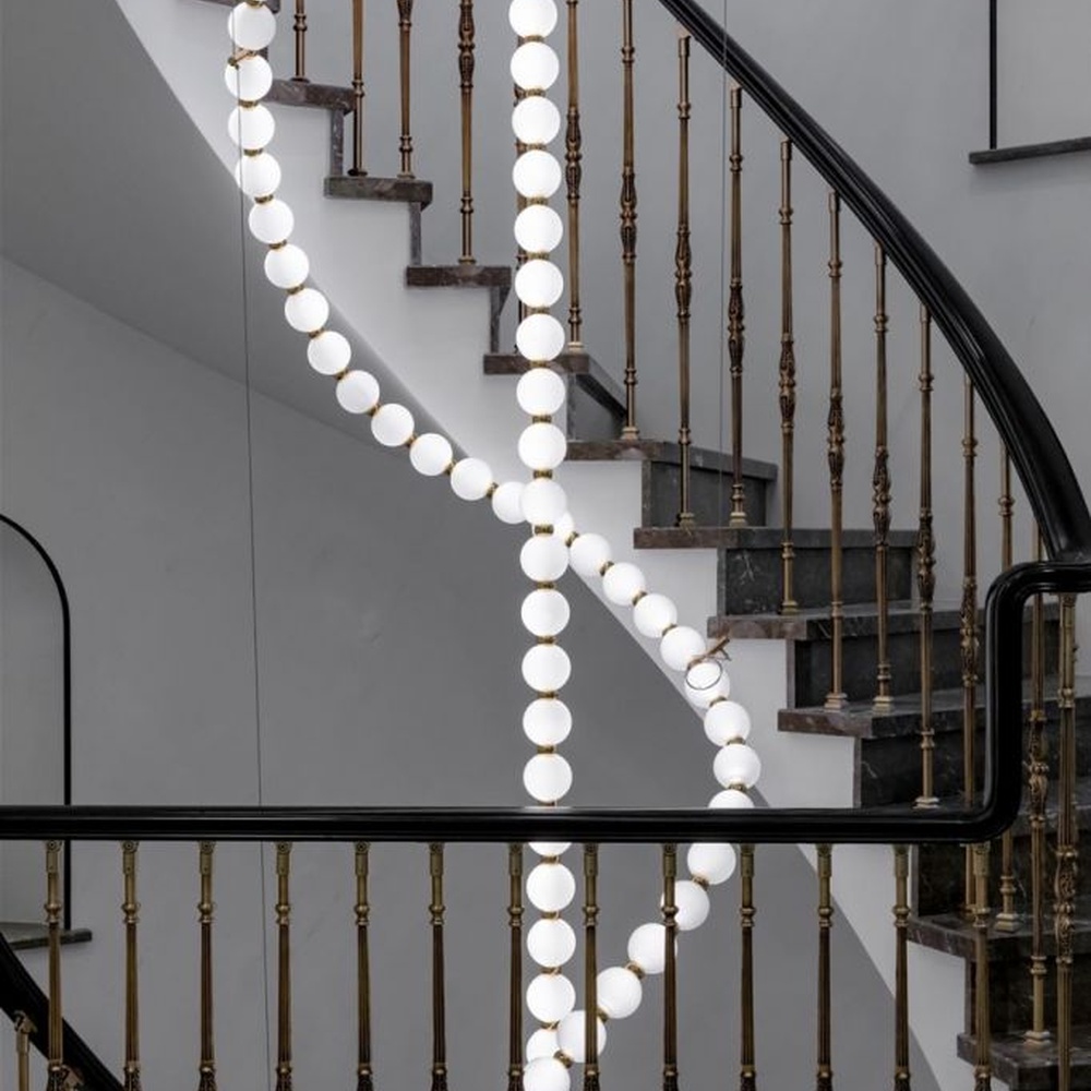Modern Art Spiral Beaded Chandelier, Composed of Milk White Spherical Lamps Connected in a Spiral Shape Following Staircase Curves, with Gold Metal Details, Serves Both Lighting and Decorative Purposes, Ideal for Villa Spiral Staircases, High-Ceiling Halls, Luxury Hotel Lobbies, etc.
