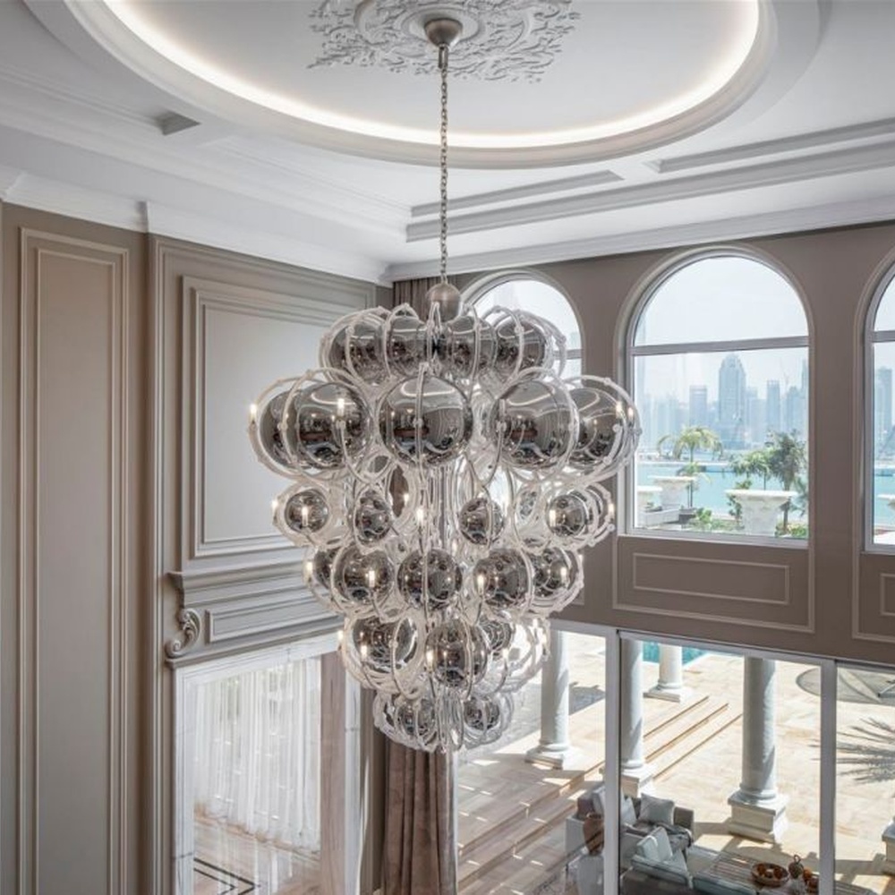 This European luxury art crystal chandelier is made of hand-blown transparent glass/crystal, with an irregular curled and twisted shape that presents a visual effect like a blooming firework. The light refracts through the crystal to emit a brilliant glow, serving both lighting and decorative purposes, suitable for luxury spaces such as high-ceiling villa living rooms and high-end clubs.