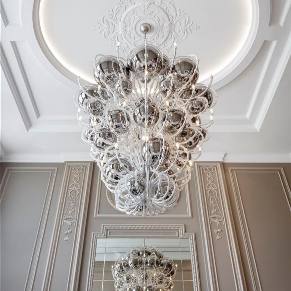 This European luxury art crystal chandelier is made of hand-blown transparent glass/crystal, with an irregular curled and twisted shape that presents a visual effect like a blooming firework. The light refracts through the crystal to emit a brilliant glow, serving both lighting and decorative purposes, suitable for luxury spaces such as high-ceiling villa living rooms and high-end clubs.