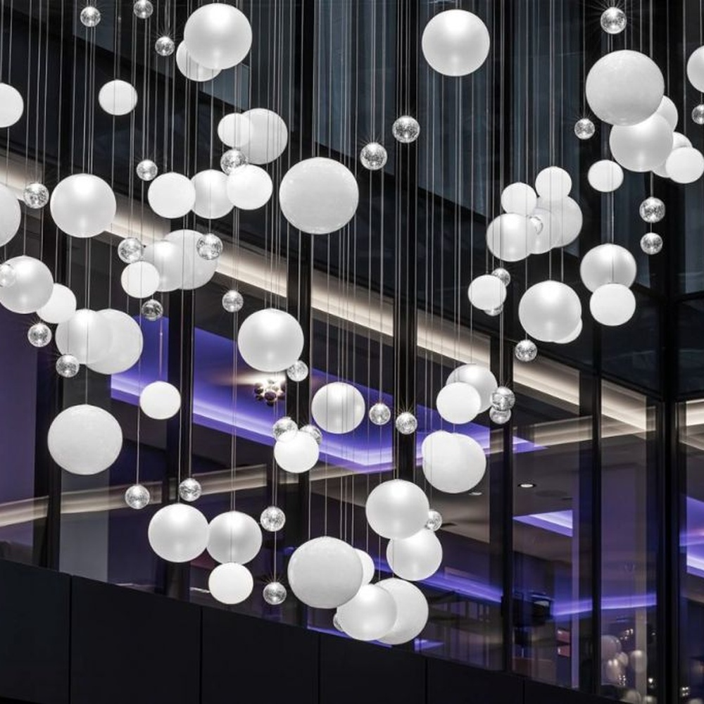 This is a modern art-style suspended spherical light array, composed of densely hung white spherical LED lights of varying sizes, presenting a flowing cloud cluster effect, with both decorative and lighting functions, ideal for public commercial spaces such as shopping mall atriums and high-ceiling office buildings.