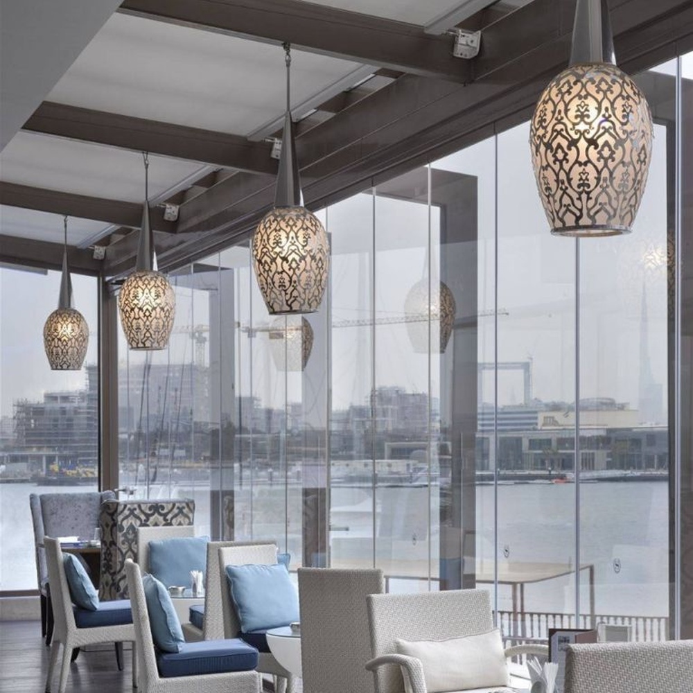 This light luxury black-gold hollow egg-shaped chandelier features retro scroll patterns carved from metal, with warm light refracting delicate shadows through the hollow texture, serving both lighting and decorative purposes, suitable for light luxury spaces such as restaurants and hotel corridors.