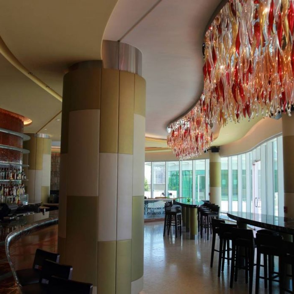 This red-gold gradient liuli leaf art chandelier is made of liuli leaf-shaped ornaments, layered into an arc-shaped drooping shape, with light refracting a colorful halo through it, serving both lighting and installation art purposes, suitable for trendy commercial spaces such as bars and clubs.