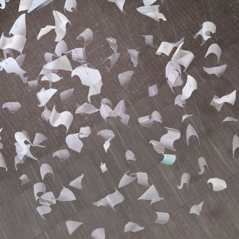 This large butterfly crystal art chandelier features a drooping shape made of transparent butterfly-shaped ornaments and crystal beads, with light refracting a soft halo through it, serving both lighting and installation art purposes, suitable for high-end luxury spaces such as hotel lobbies and high-ceiling clubs.