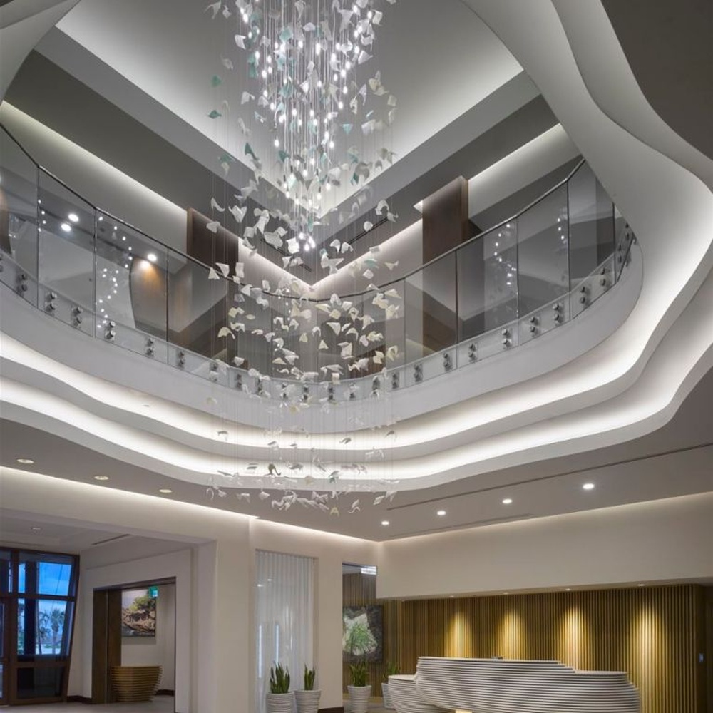 This large butterfly crystal art chandelier features a drooping shape made of transparent butterfly-shaped ornaments and crystal beads, with light refracting a soft halo through it, serving both lighting and installation art purposes, suitable for high-end luxury spaces such as hotel lobbies and high-ceiling clubs.