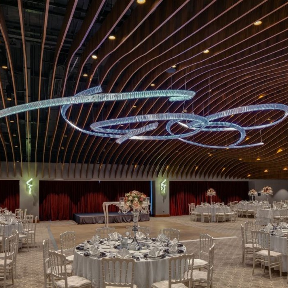 This red spiral crystal art chandelier is composed of red crystal strips spliced into a flowing spiral shape. Light refracts through to emit a brilliant halo, serving both lighting and installation art purposes, suitable for trendy commercial spaces such as bars and clubs.