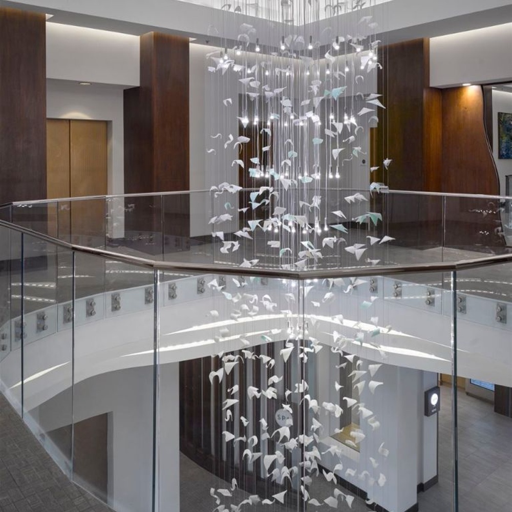 This large butterfly crystal art chandelier features a drooping shape made of transparent butterfly-shaped ornaments and crystal beads, with light refracting a soft halo through it, serving both lighting and installation art purposes, suitable for high-end luxury spaces such as hotel lobbies and high-ceiling clubs.