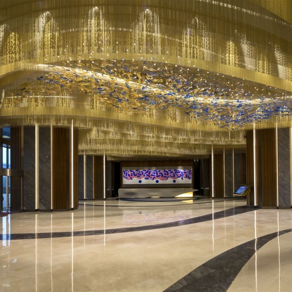 This blue-gold gradient liuli leaf art chandelier is made of liuli leaf-shaped ornaments, layered to create a flowing visual effect. Light refracts through to emit a colorful halo, serving both lighting and installation art purposes, suitable for luxury spaces such as hotel lobbies and high-end clubs.