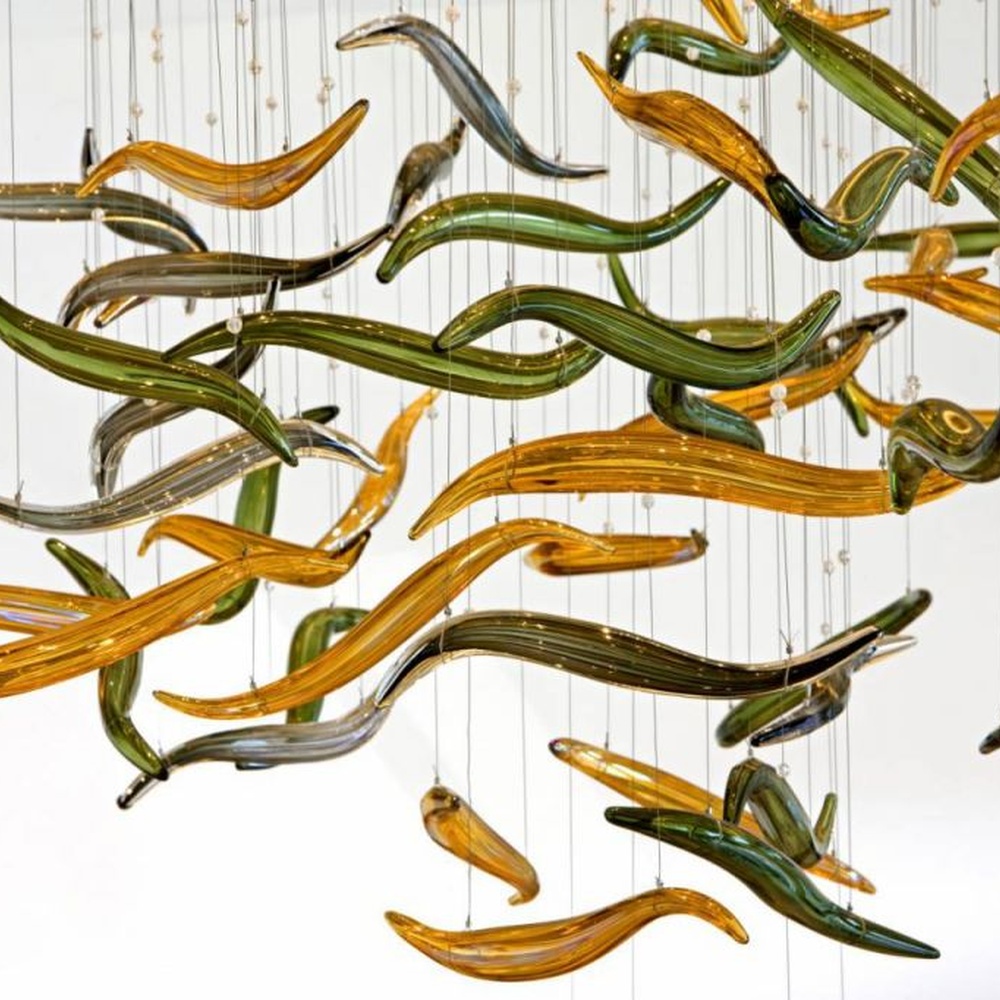 This red-gold gradient liuli leaf art chandelier is made of liuli leaf-shaped ornaments, layered into an arc-shaped drooping shape, with light refracting a colorful halo through it, serving both lighting and installation art purposes, suitable for trendy commercial spaces such as bars and clubs.