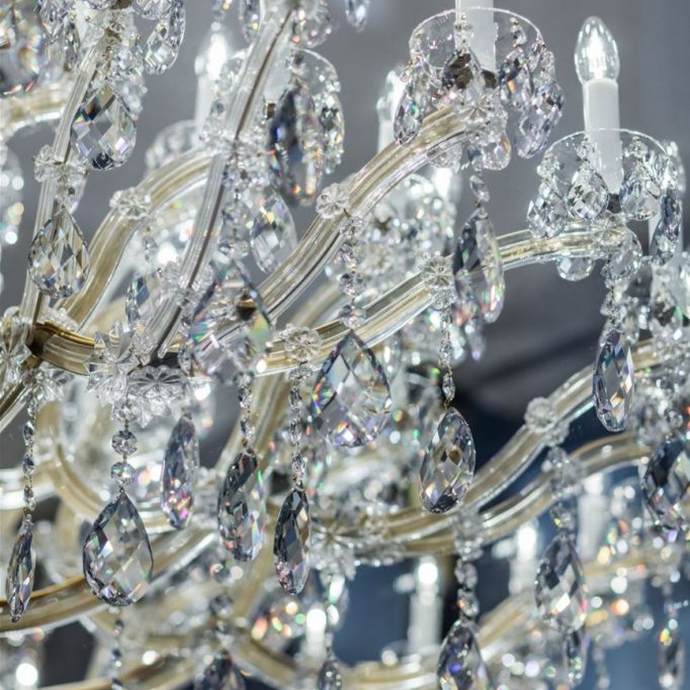 This European court-style multi-layer crystal chandelier features a gold metal frame, paired with faceted crystals and candle-style lamp heads, with light refracting a brilliant halo through the crystals, serving both lighting and decorative purposes, suitable for luxury spaces such as high-end restaurants and clubs.