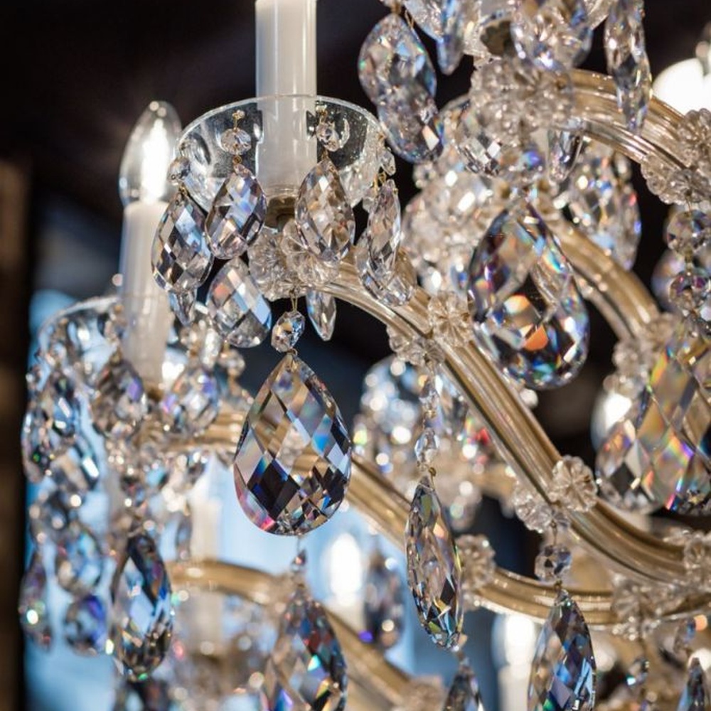 This European court-style multi-layer crystal chandelier features a gold metal frame, paired with faceted crystals and candle-style lamp heads, with light refracting a brilliant halo through the crystals, serving both lighting and decorative purposes, suitable for luxury spaces such as high-end restaurants and clubs.