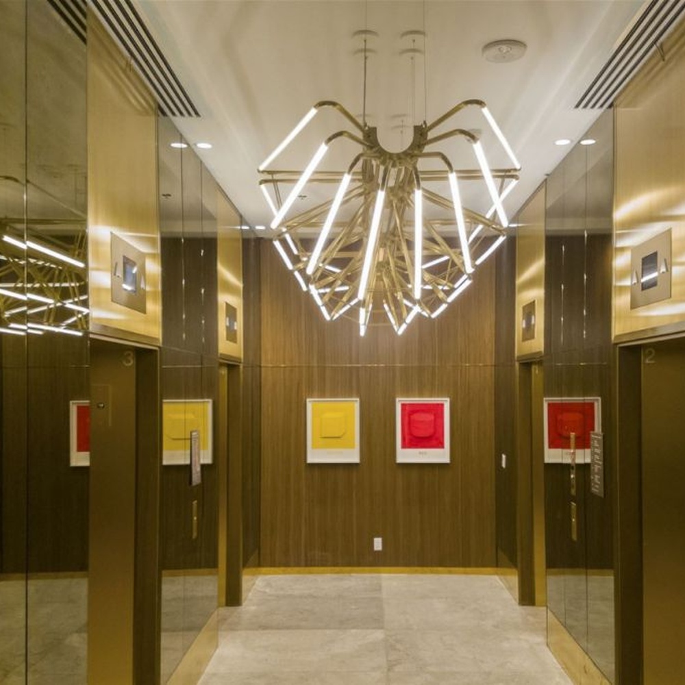 This modern art branch chandelier features an interlaced branch structure made of gold metal, paired with LED strips to form a starburst shape, with soft and visually striking light, serving both lighting and decorative purposes, suitable for high-end modern spaces such as elevator lobbies and clubs.