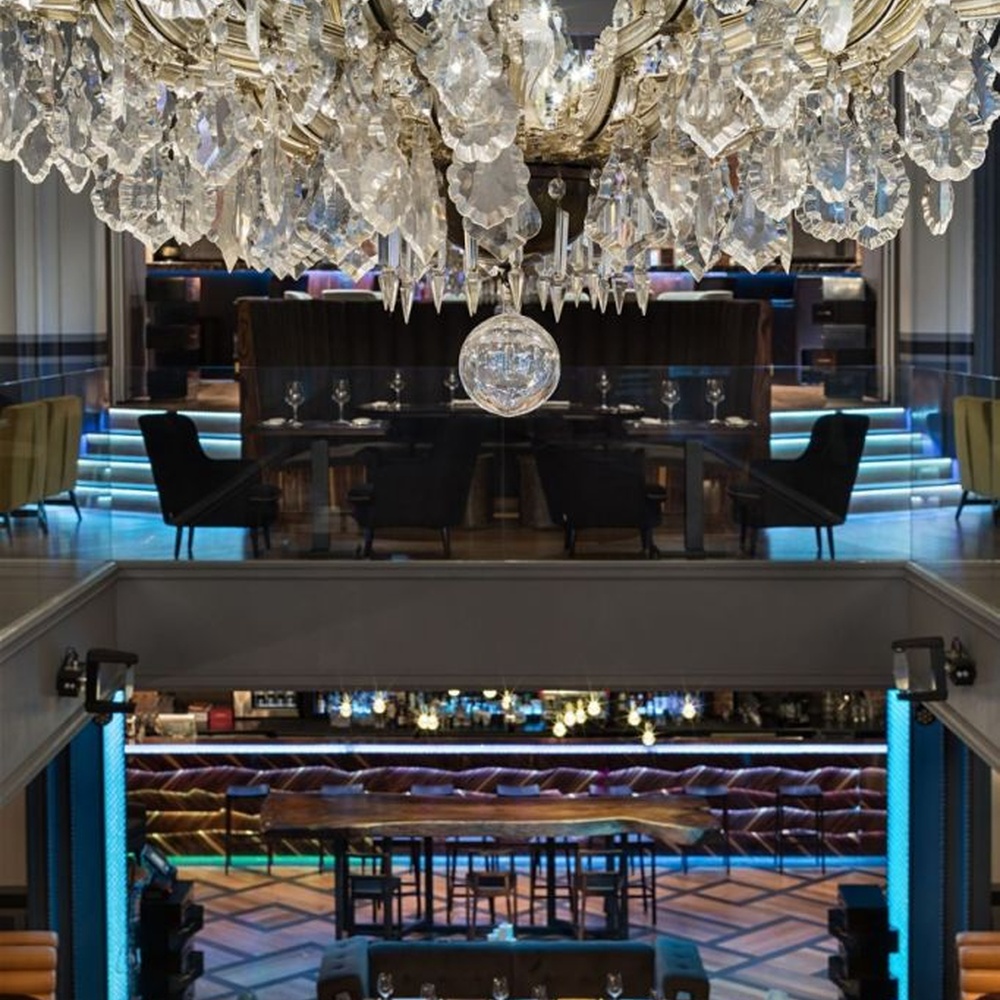 This light luxury interlaced ring crystal chandelier features a multi-layer flowing ring shape made of metal frames and crystal strips, with light refracting a brilliant halo through the crystals, serving both lighting and decorative purposes, suitable for modern light luxury spaces such as living rooms and dining rooms.