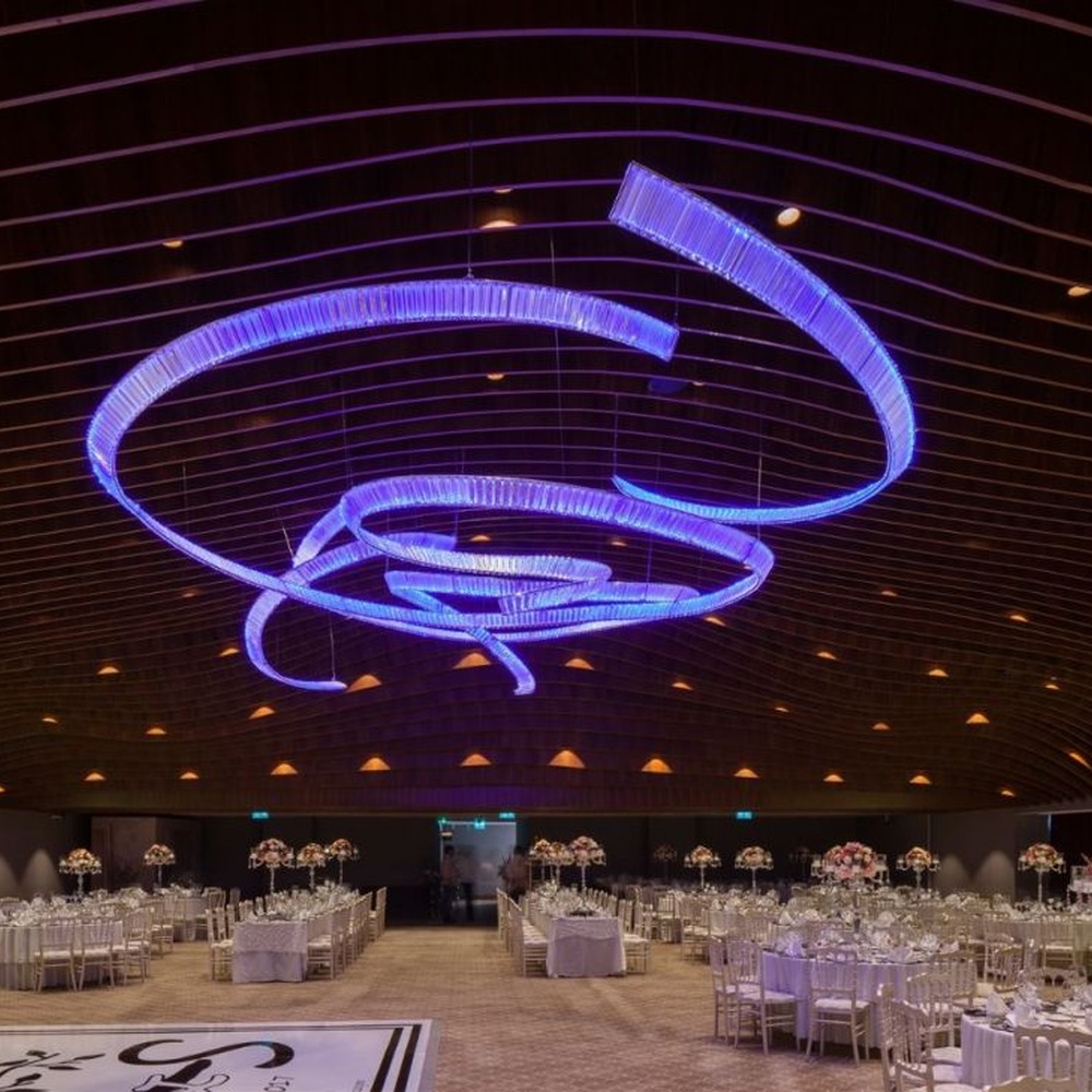 This red spiral crystal art chandelier is composed of red crystal strips spliced into a flowing spiral shape. Light refracts through to emit a brilliant halo, serving both lighting and installation art purposes, suitable for trendy commercial spaces such as bars and clubs.