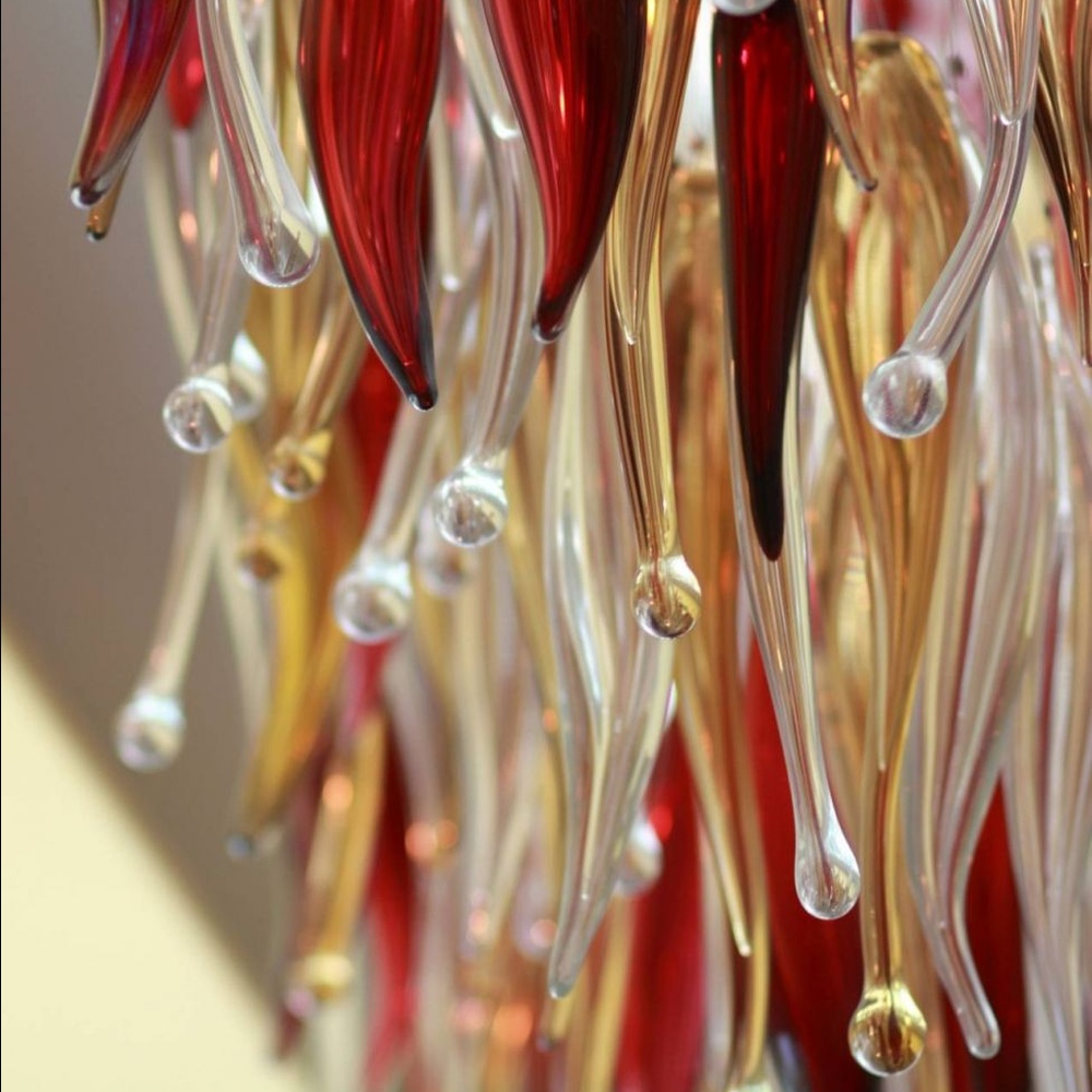 This red-gold gradient liuli leaf art chandelier is made of liuli leaf-shaped ornaments, layered into an arc-shaped drooping shape, with light refracting a colorful halo through it, serving both lighting and installation art purposes, suitable for trendy commercial spaces such as bars and clubs.