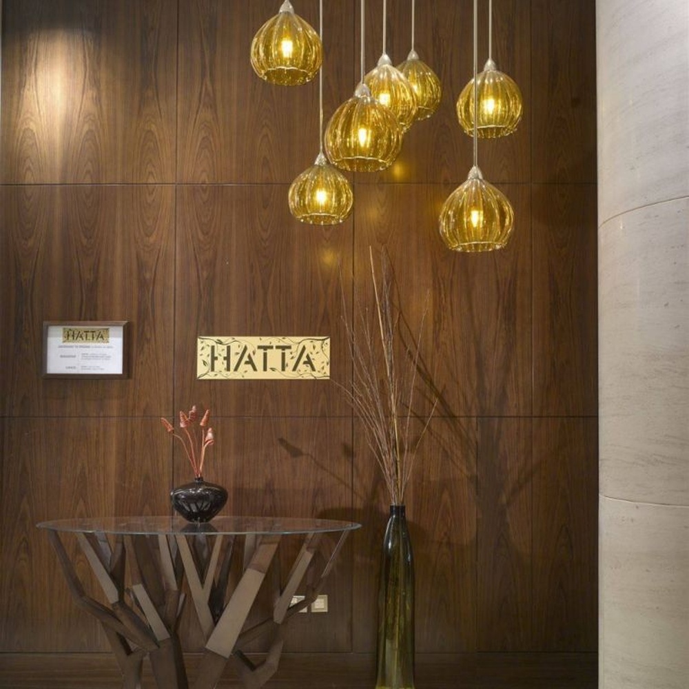 This light luxury black-gold hollow egg-shaped chandelier features retro scroll patterns carved from metal, with warm light refracting delicate shadows through the hollow texture, serving both lighting and decorative purposes, suitable for light luxury spaces such as restaurants and hotel corridors.