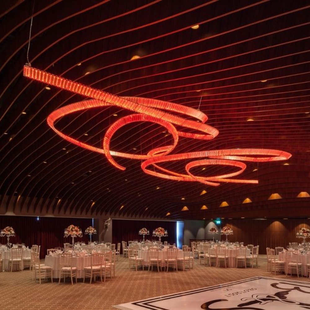 This red spiral crystal art chandelier is composed of red crystal strips spliced into a flowing spiral shape. Light refracts through to emit a brilliant halo, serving both lighting and installation art purposes, suitable for trendy commercial spaces such as bars and clubs.