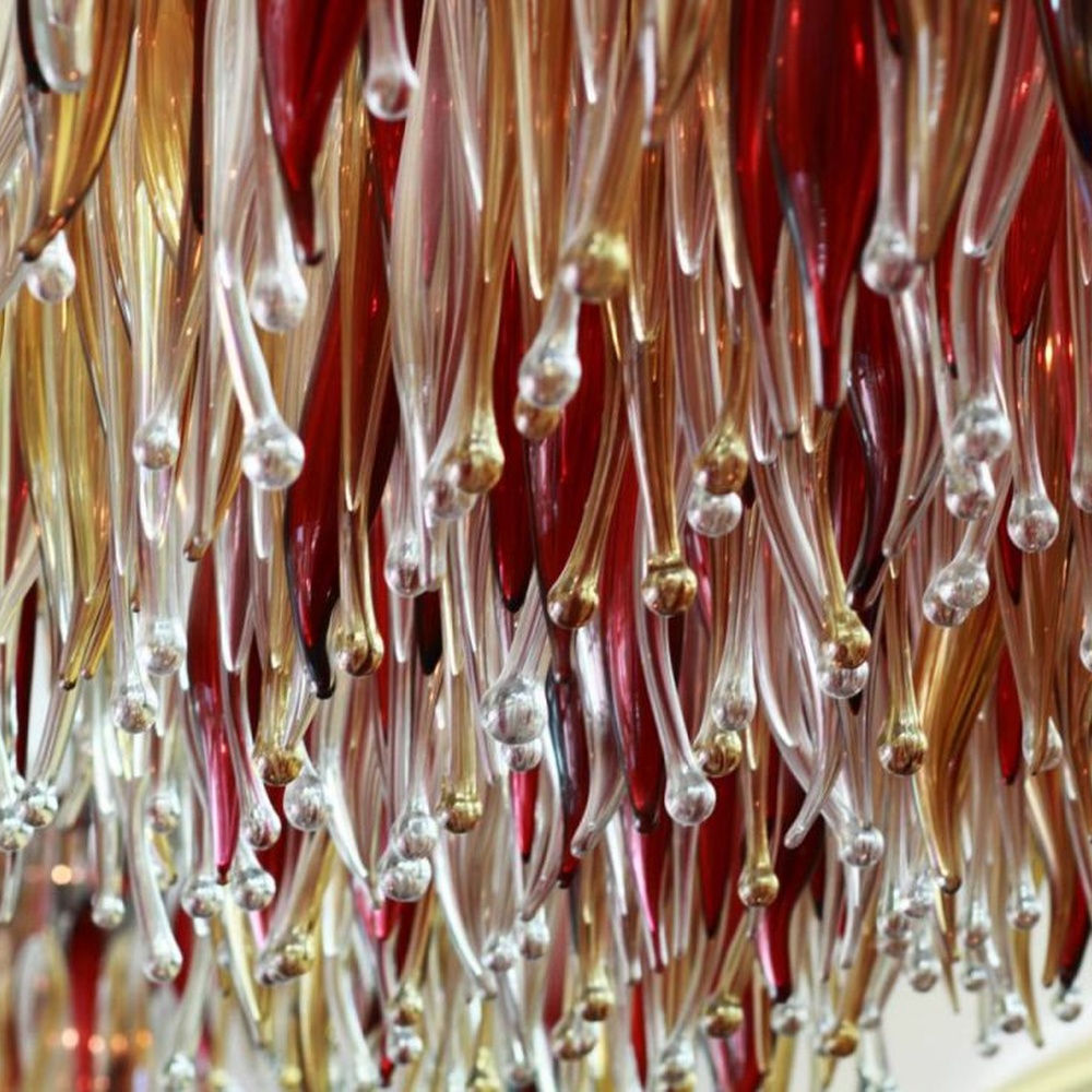 This red-gold gradient liuli leaf art chandelier is made of liuli leaf-shaped ornaments, layered into an arc-shaped drooping shape, with light refracting a colorful halo through it, serving both lighting and installation art purposes, suitable for trendy commercial spaces such as bars and clubs.