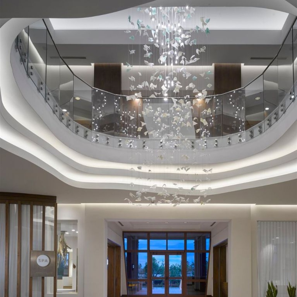 This large butterfly crystal art chandelier features a drooping shape made of transparent butterfly-shaped ornaments and crystal beads, with light refracting a soft halo through it, serving both lighting and installation art purposes, suitable for high-end luxury spaces such as hotel lobbies and high-ceiling clubs.