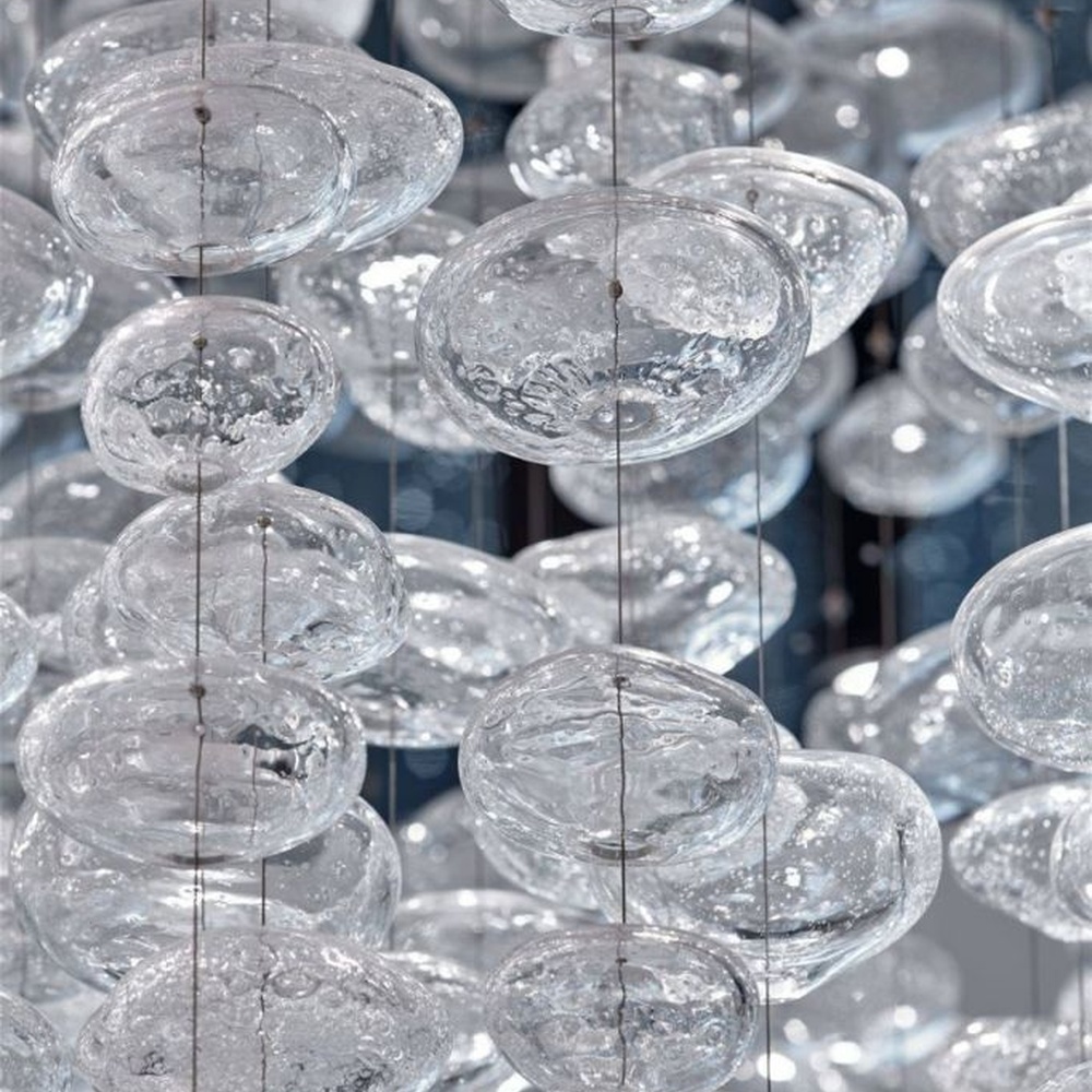 This cloud-like liuli bubble art ceiling lamp is made of transparent liuli bubbles layered into a flowing cloud shape, with light refracting a soft halo through it, serving both lighting and installation art purposes, suitable for modern luxury spaces such as high-end sales offices and clubs.
