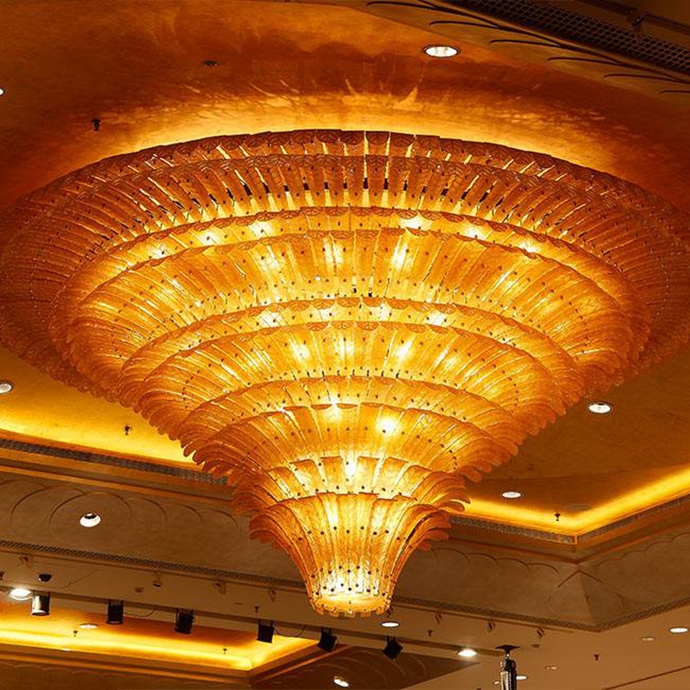 European luxury dome-style multi-layer crystal chandelier, with a golden metal frame and transparent crystal layered structure, featuring bright and grand light, combining main lighting and space decoration functions, suitable for large-scale commercial spaces such as hotel banquet halls, high-end clubs, and large conference halls.