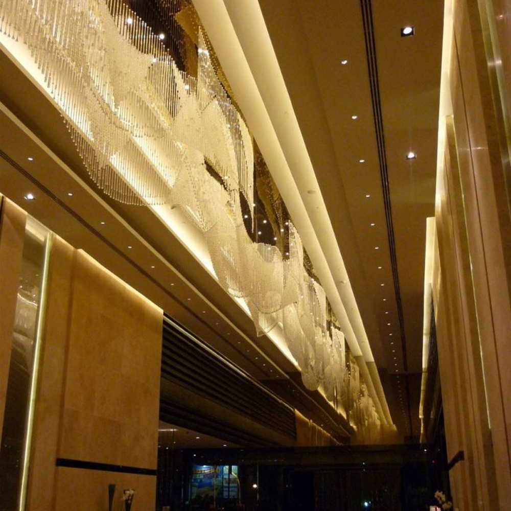 Modern luxury linear hanging crystal lamp group, made of dense crystal strips and particles stacked to create a flowing light belt shape, combining decorative and lighting functions, suitable for large-scale commercial spaces such as hotel lobbies, high-end clubs, and commercial atriums.