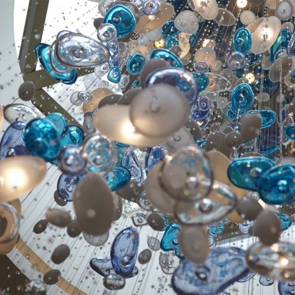 Modern artistic ocean-style hanging chandelier, made of blue-white gradient glass/crystal pieces to create a streamlined bubble shape, combining decorative and main lighting functions, suitable for high-ceiling spaces such as hotel lobbies and high-end clubs.