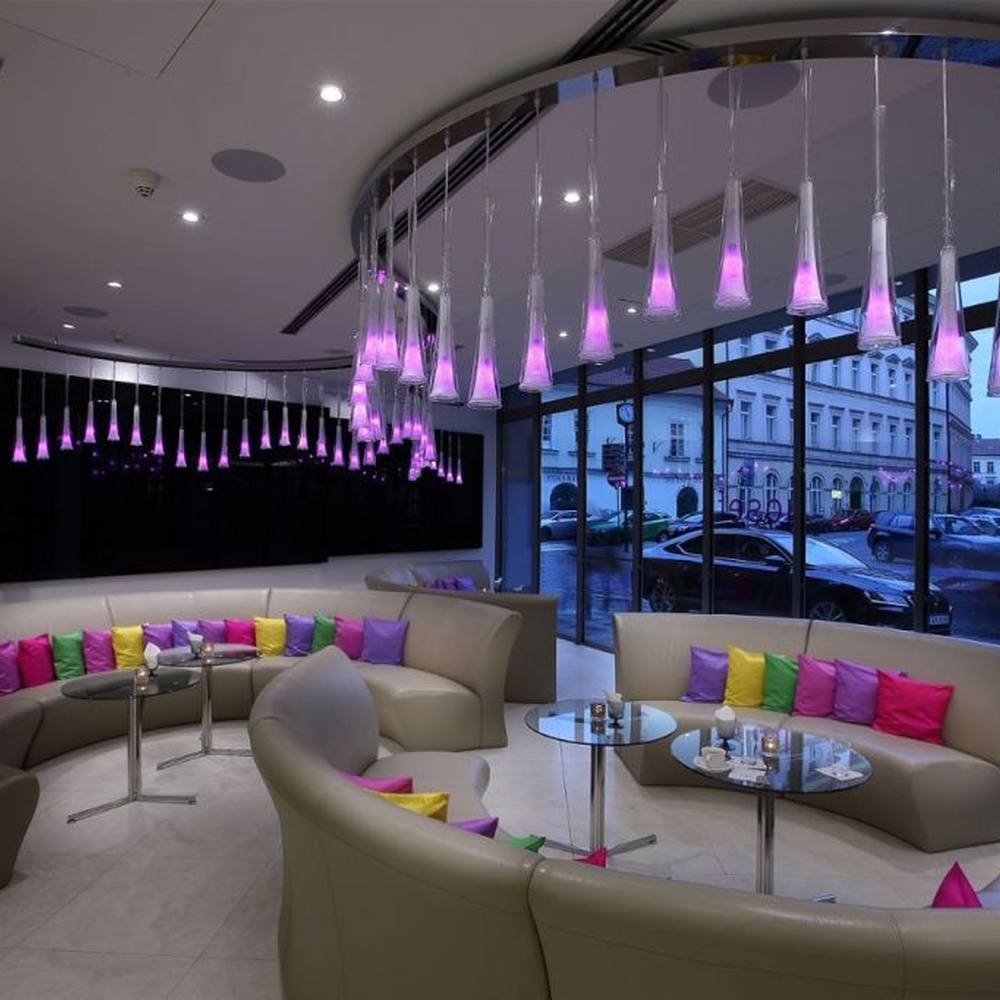 This modern gradient cone LED chandelier features transparent conical lampshades paired with LED gradient pink-purple light sources, arranged in a staggered drooping manner with slender suspension rods, with soft and dreamy light, serving both lighting and decorative purposes, suitable for modern entertainment commercial spaces such as bars and lounges.
