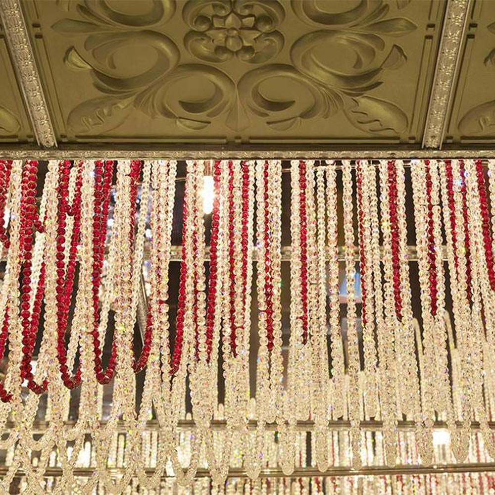Modern luxury red-white gradient wavy crystal ceiling lamp, with dense crystal particles creating a flowing wavy shape, the red-white gradient texture has strong visual tension, combining decorative and main lighting functions, suitable for large-scale commercial spaces such as high-end banquet halls, clubs, and hotel lobbies.