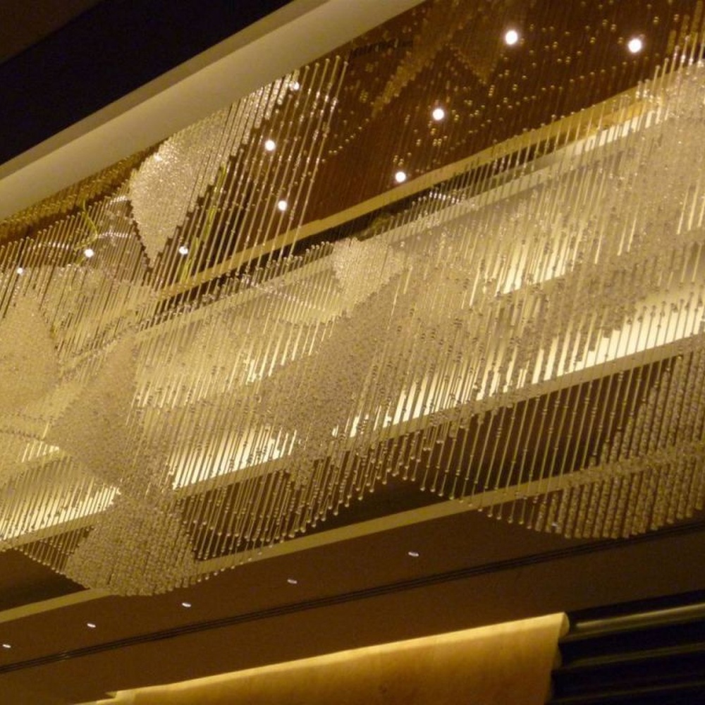 Modern luxury linear hanging crystal lamp group, made of dense crystal strips and particles stacked to create a flowing light belt shape, combining decorative and lighting functions, suitable for large-scale commercial spaces such as hotel lobbies, high-end clubs, and commercial atriums.