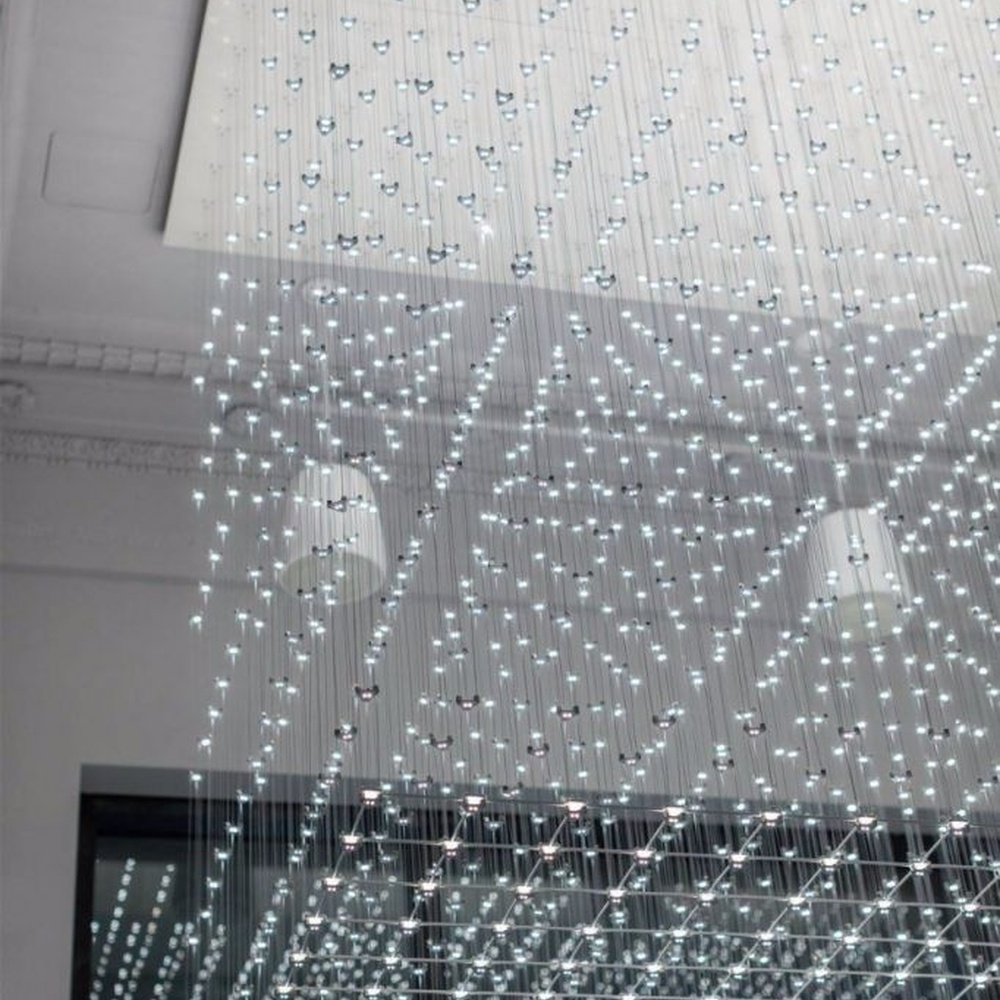 Modern artistic matrix-style hanging crystal lamp group, composed of dense crystal particles/LED beads suspended by thin wires to form a transparent light curtain, combining decorative and ambient lighting functions, suitable for high-ceiling spaces such as hotel lobbies, commercial atriums, and art exhibition halls.