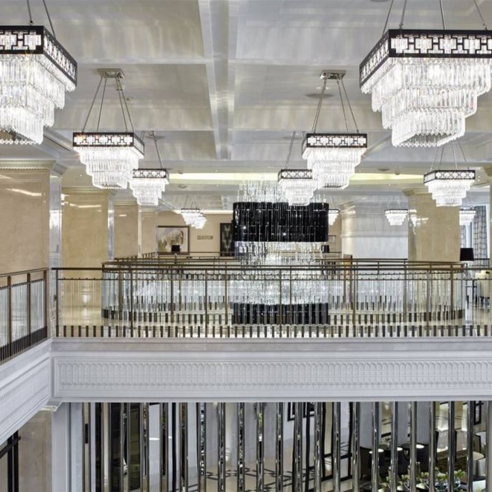 Modern light luxury rectangular multi-layer crystal chandelier, with a black-framed metal frame and layered transparent crystal strips, featuring bright and soft light, combining decorative and lighting functions, suitable for hotel lobbies, high-end clubs, commercial atriums and other high-ceiling commercial spaces.