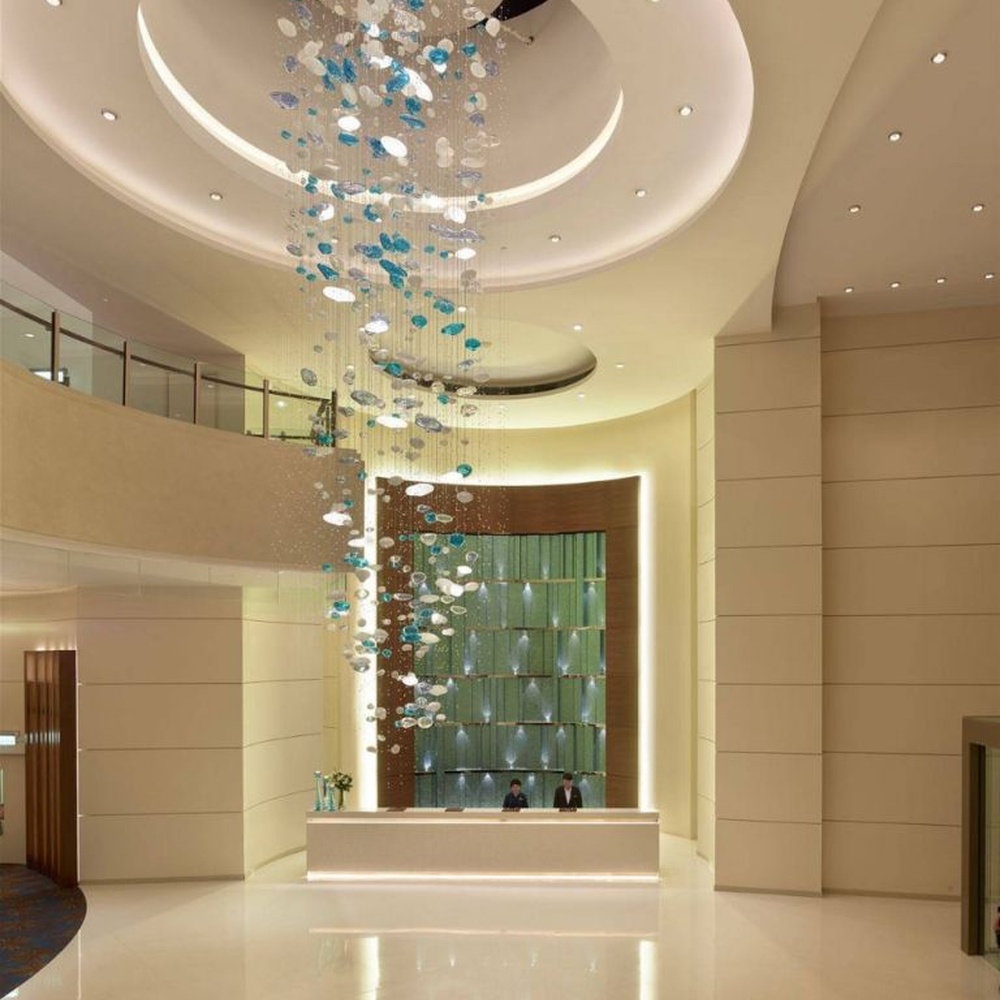 Modern artistic ocean-style hanging chandelier, made of blue-white gradient glass/crystal pieces to create a streamlined bubble shape, combining decorative and main lighting functions, suitable for high-ceiling spaces such as hotel lobbies and high-end clubs.