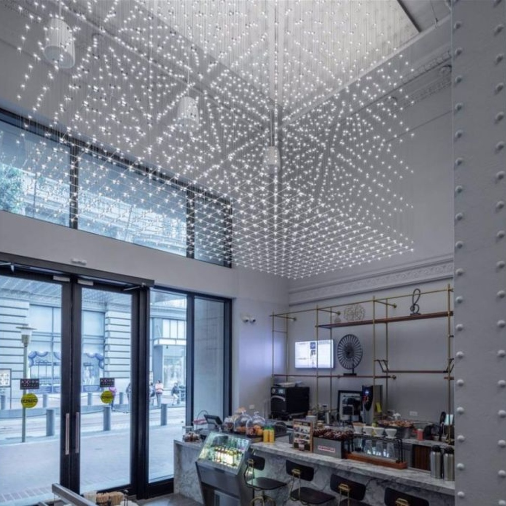 Modern artistic matrix-style hanging crystal lamp group, composed of dense crystal particles/LED beads suspended by thin wires to form a transparent light curtain, combining decorative and ambient lighting functions, suitable for high-ceiling spaces such as hotel lobbies, commercial atriums, and art exhibition halls.