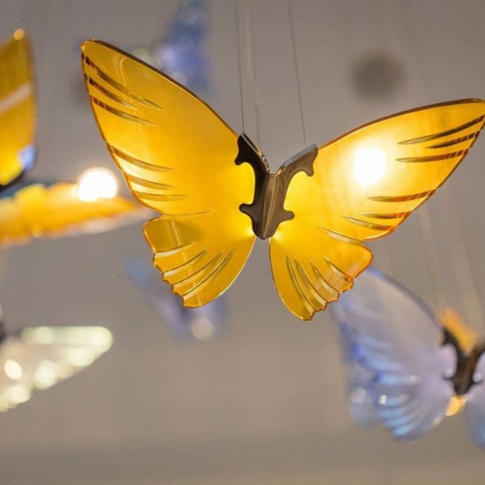 Modern artistic butterfly-shaped suspended chandelier, made of colored glass/acrylic to create a realistic butterfly form, paired with adjustable metal suspension rods, combining decorative and ambient lighting functions, suitable for hotel lobbies, high-end clubs, art exhibition halls and other spaces.