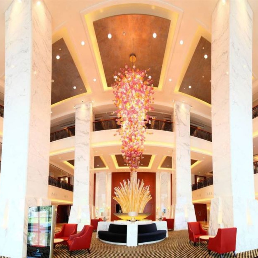 Modern artistic flower cluster-shaped hanging chandelier, with pink-orange gradient crystal/acrylic petals stacked into a full flower cluster shape, combining artistic decoration and main lighting functions, suitable for high-ceiling large-scale spaces such as hotel lobbies, high-end clubs, and commercial atriums.

