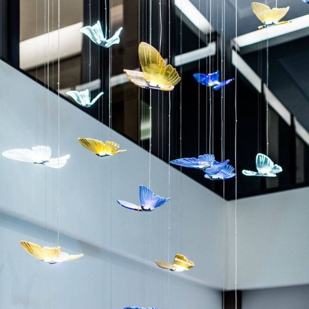 Modern artistic butterfly-shaped suspended chandelier, made of colored glass/acrylic to create a realistic butterfly form, paired with adjustable metal suspension rods, combining decorative and ambient lighting functions, suitable for hotel lobbies, high-end clubs, art exhibition halls and other spaces.