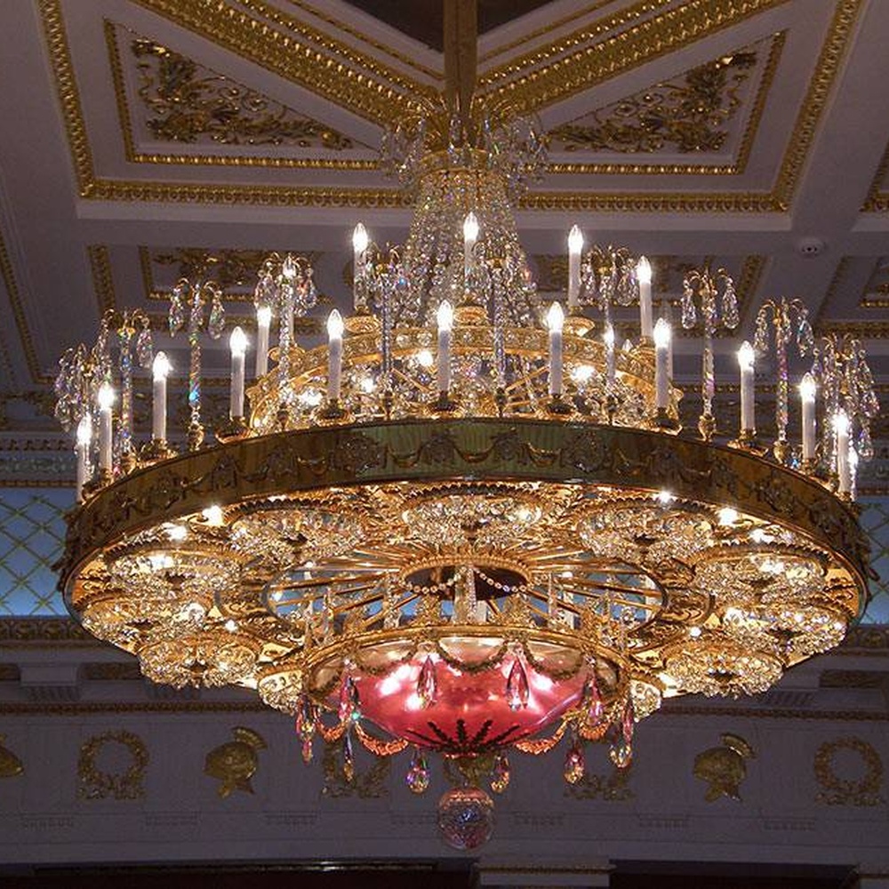 European palace-style multi-layer crystal chandelier, with a golden retro metal frame and brilliant crystal decorations, featuring a gorgeous and solemn appearance, combining main lighting and space decoration functions, suitable for palace exhibition halls, high-end clubs, luxury villas and other European-style spaces.