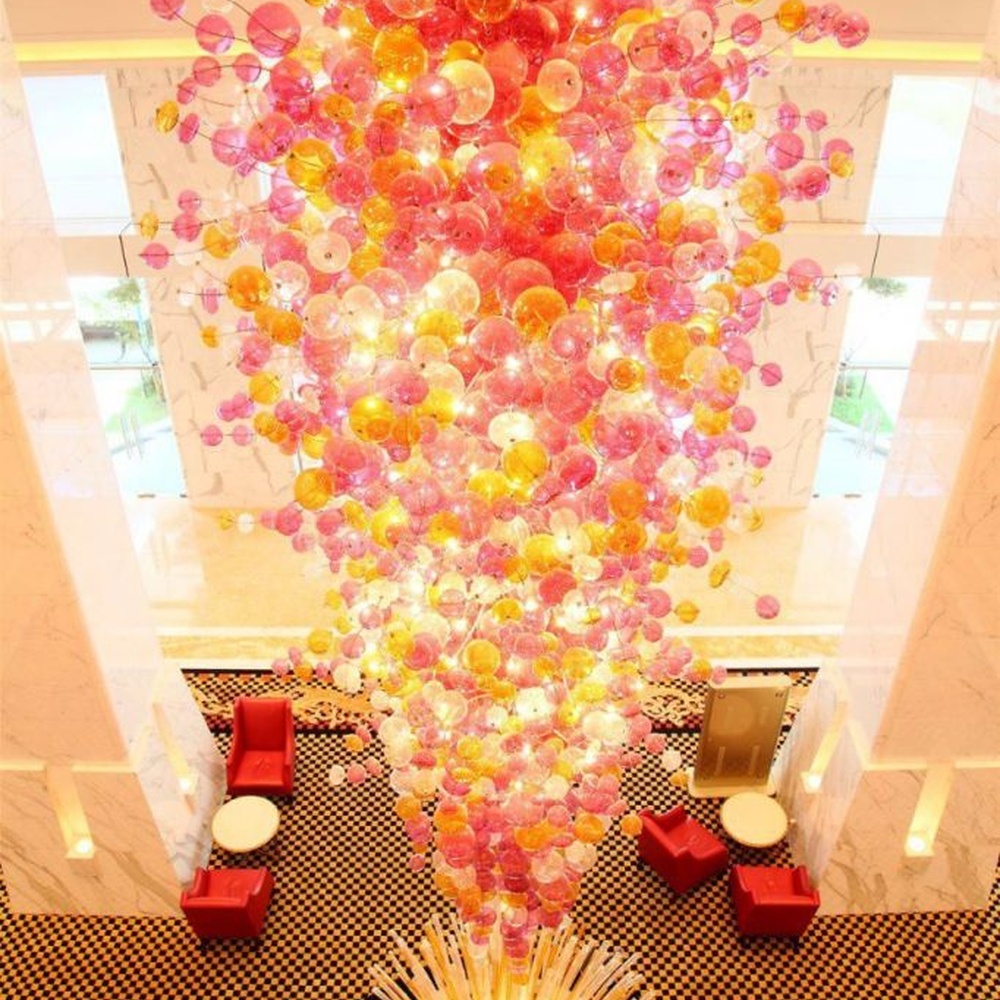 Modern artistic flower cluster-shaped hanging chandelier, with pink-orange gradient crystal/acrylic petals stacked into a full flower cluster shape, combining artistic decoration and main lighting functions, suitable for high-ceiling large-scale spaces such as hotel lobbies, high-end clubs, and commercial atriums.
